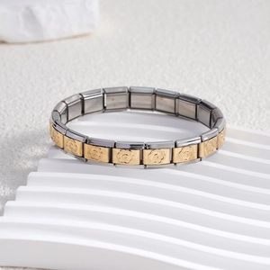 Détail d'un bracelet italien en acier inoxydable avec maillons fleuris dorés