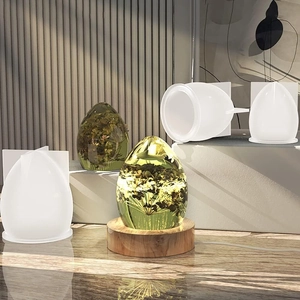 Close-up of egg-shaped resin mold with glowing wooden LED base and floral crystal resin art