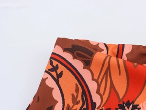 Close-up of ethnic floral print fabric with knot detail and stitching on mini skirt