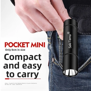 Compact 8cm black LED flashlight showing portable design tucked into a jean pocket