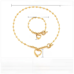 Macro view of gold stainless steel heart link necklace and bracelet set with toggle clasp