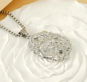 Macro detail of silver dragon relief pendant on white textured petals with square pearl chain