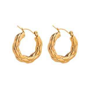 Détail macro de boucles d'oreilles en acier inoxydable doré 18 carats à motifs de losanges