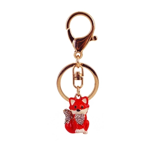 Golden fox keychain with red crystal charm and diamond-set tail on white background