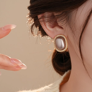 Close-up of model wearing retro oval champagne earrings with gold frame and zircons