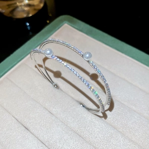 Detailed view of silver double-layered cuff bracelet with pearls and pavé zircon stones