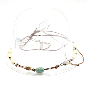 Close-up of bohemian hat band with wood beads, seashells, and turquoise accents