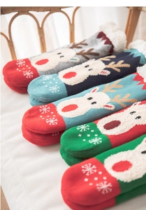 Detailed view of fleece Christmas socks with 3D reindeer patches and snowflake patterns