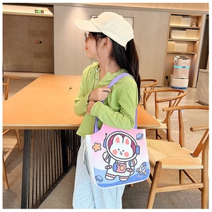 Detail of canvas tote bag with colorful astronaut rabbit pattern and purple handle