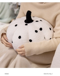 Detail of soft white pumpkin plush with black polka dots and velvet texture