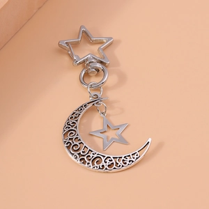 Silver hollow crescent moon and star keychain pendant with pentagram clasp on beige background