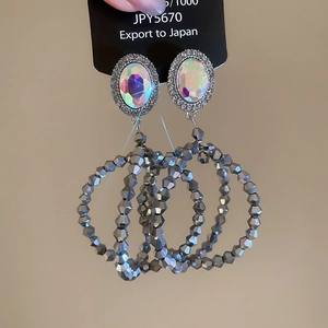 Détail de boucles d'oreilles de luxe avec cristaux AB et grands cercles perlés