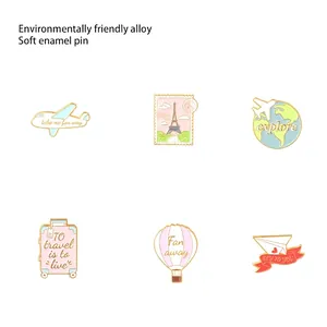 Pink travel enamel pin set with airplane, globe, and luggage shapes for clothing accessories