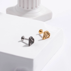 Detailed view of hollow diamond-shaped labret studs in silver and gold finishes