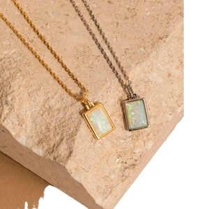 Rectangle opal pendant necklaces in gold and silver finish on natural stone background