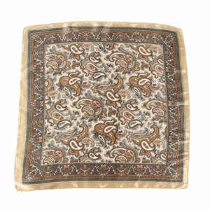 Detail showing classic paisley pattern on beige and brown silk-like square scarf