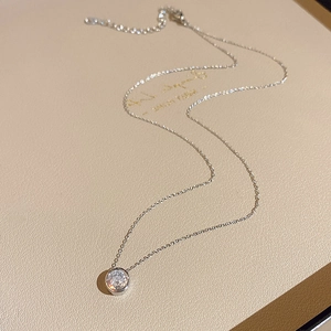 Dettaglio macro di una collana a cuore in argento lucido con zircone rotondo brillante