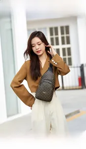 Close-up of stylish leopard print crossbody bag with multiple zippers and adjustable strap