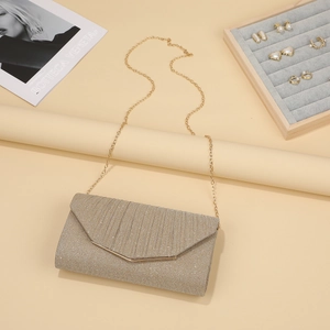 Detail of glitter evening clutch with V-shaped flap and gold metal chain strap