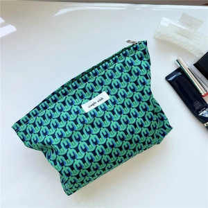 Detail of green and blue geometric pattern cotton makeup bag with zipper closure