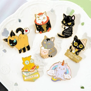 Detailed view of seven cartoon cat enamel pins featuring fun phrases on a white ceramic plate