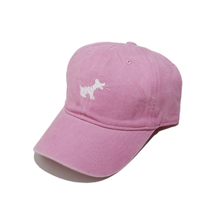 Detail view of pink washed cotton baseball cap with white dog embroidery and vintage texture