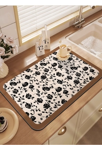 Detail of floral absorbent kitchen mat with rose patterns on a wooden countertop