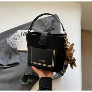 Black PU leather bucket bag with gold rivets, wide patterned strap and rabbit charm