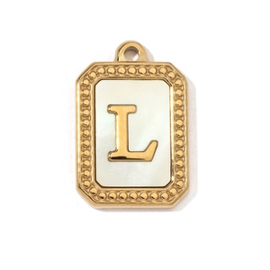 Detailed view of vintage gold letter L pendant with elegant white shell inlay
