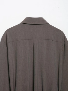 Vue macro détaillée de l'empiècement arrière et des plis sur une chemise marron