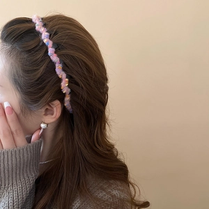 Detail of colorful knit headband with sequins on brunette hair for a soft winter look
