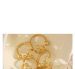 Detail shot of stackable 18K gold plated zircon pearl rings in a ceramic bowl