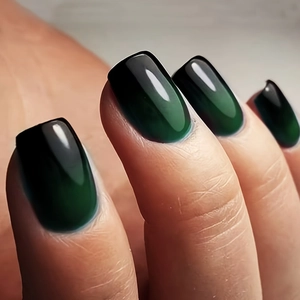 Gros plan d'ongles adhésifs vert foncé brillants de forme carrée-ovale à effet miroir