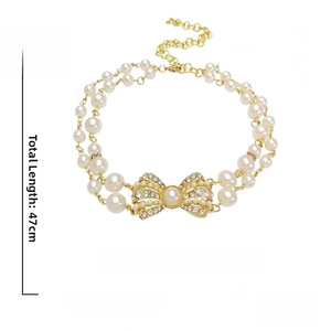 Dettaglio della collana di perle a doppio strato con fiocco di strass e lunghezza di 47cm