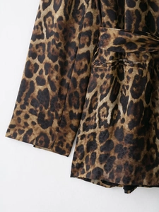 Dettaglio del tessuto della tuta leopardata che mostra texture premium e stampa animale