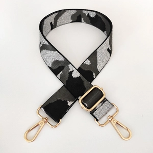 Close-up of camouflage bag strap with high-density fabric and gold metal hooks