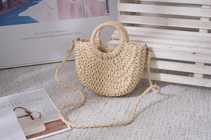 Detailansicht der halbrunden Papierschnur-Tasche mit runden Griffen und langem Gurt