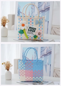 Detail of woven picnic bag featuring colorful checkered patterns and floral 3D decorations