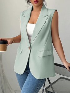 Detail view of light green sleeveless blazer vest with peak lapels and single button closure