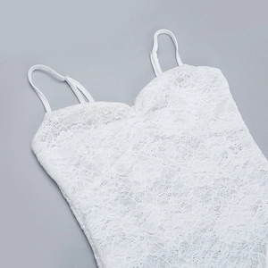 Dettaglio di un top in pizzo bianco con spalline regolabili e ricami floreali fini