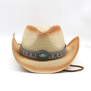 Détail d'un chapeau de cowboy en paille avec bande ethnique et pierre turquoise