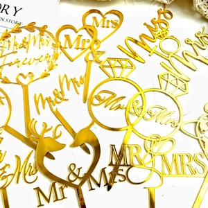 Various gold mirror acrylic Mr & Mrs wedding cake toppers with romantic heart designs