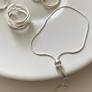Detail of S925 sterling silver snake chain bracelet and multilayer wrap ring set