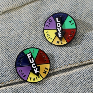 Detail of sliding social energy mood pin showing rotating pointer on denim jacket