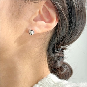 Close-up of 925 sterling silver heart stud earrings with twisted rope border design