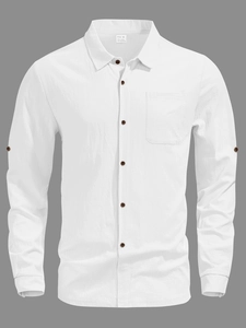 Detailed texture of white linen fabric with dark brown buttons and a single chest pocket