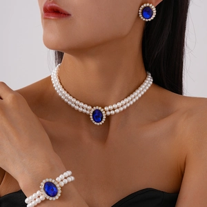 Detail of luxury three-piece jewelry set with blue oval gemstones and white pearls