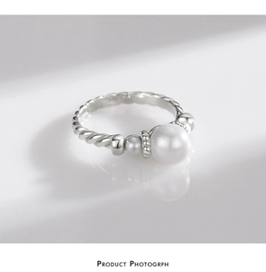 Macro view of S925 silver pearl ring featuring woven texture and white pearl detail