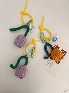Detailed close-up of handmade knitted tulip charms with purple and orange flowers