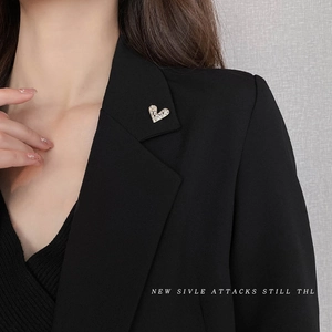 Sparkling heart brooch with embedded rhinestones on a black suit lapel, elegant accessory